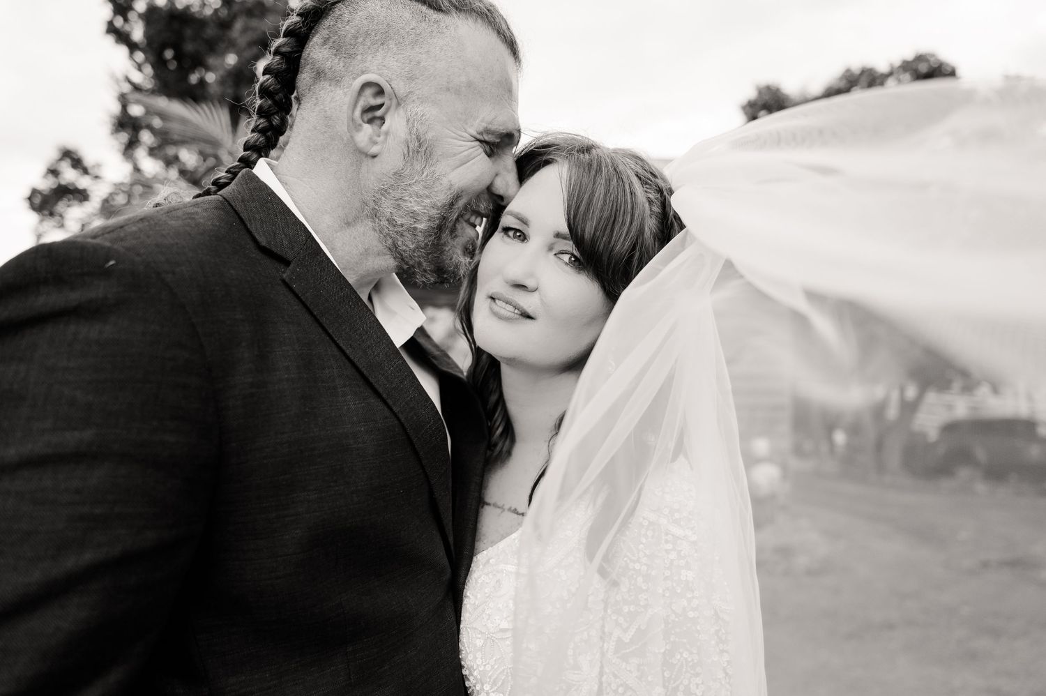 A romantic black and white portrait of newlyweds sharing an intimate moment together.