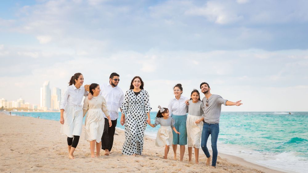 A group of people standing on top of a sandy beach - Julio Naranjo Photography