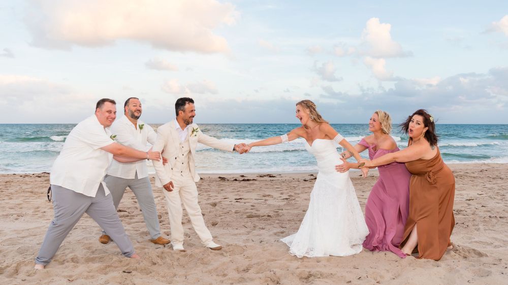 A group of people standing on top of a sandy beach - Julio Naranjo Photography