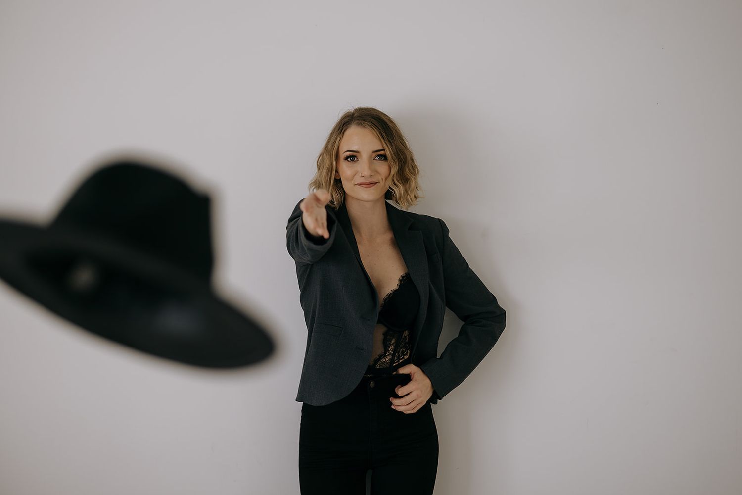 Barrie Boudoir Photographer tossing hat at the camera. Collingwood, ON. Luxury Boudoir.