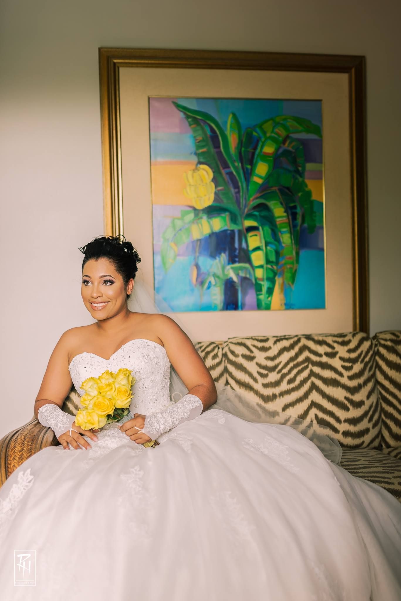 A bridal portrait with a vibrant palm tree painting and zebra print decor in the background.