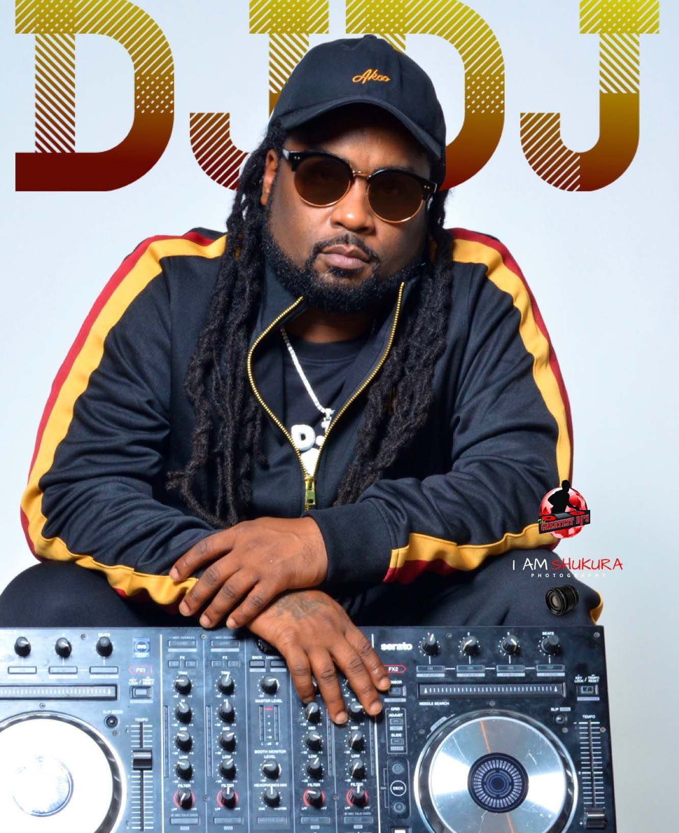 DJ portrait with mixing equipment wearing black jacket and cap against gradient background.