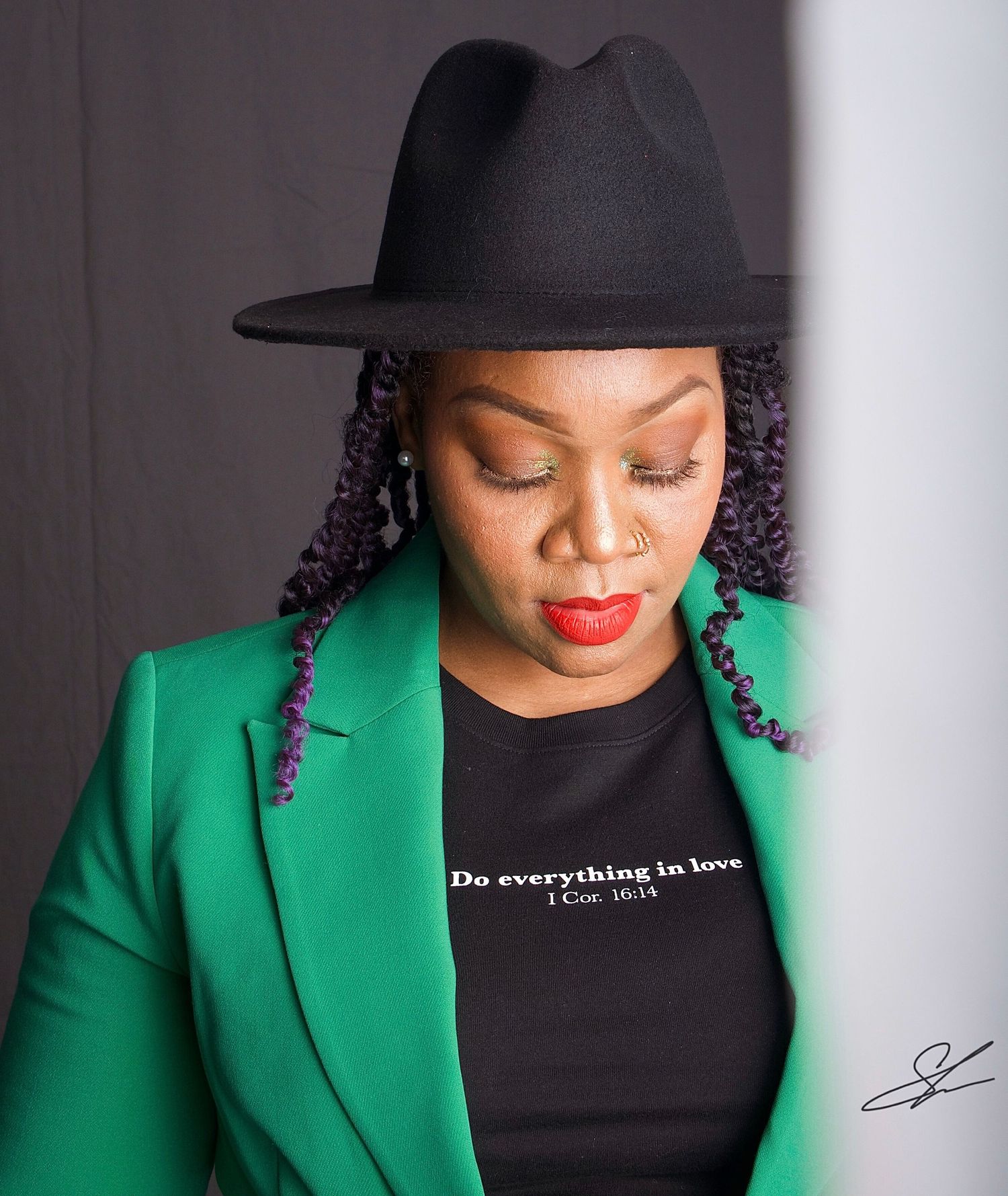 Stylish portrait featuring green blazer, black hat and statement red lipstick.