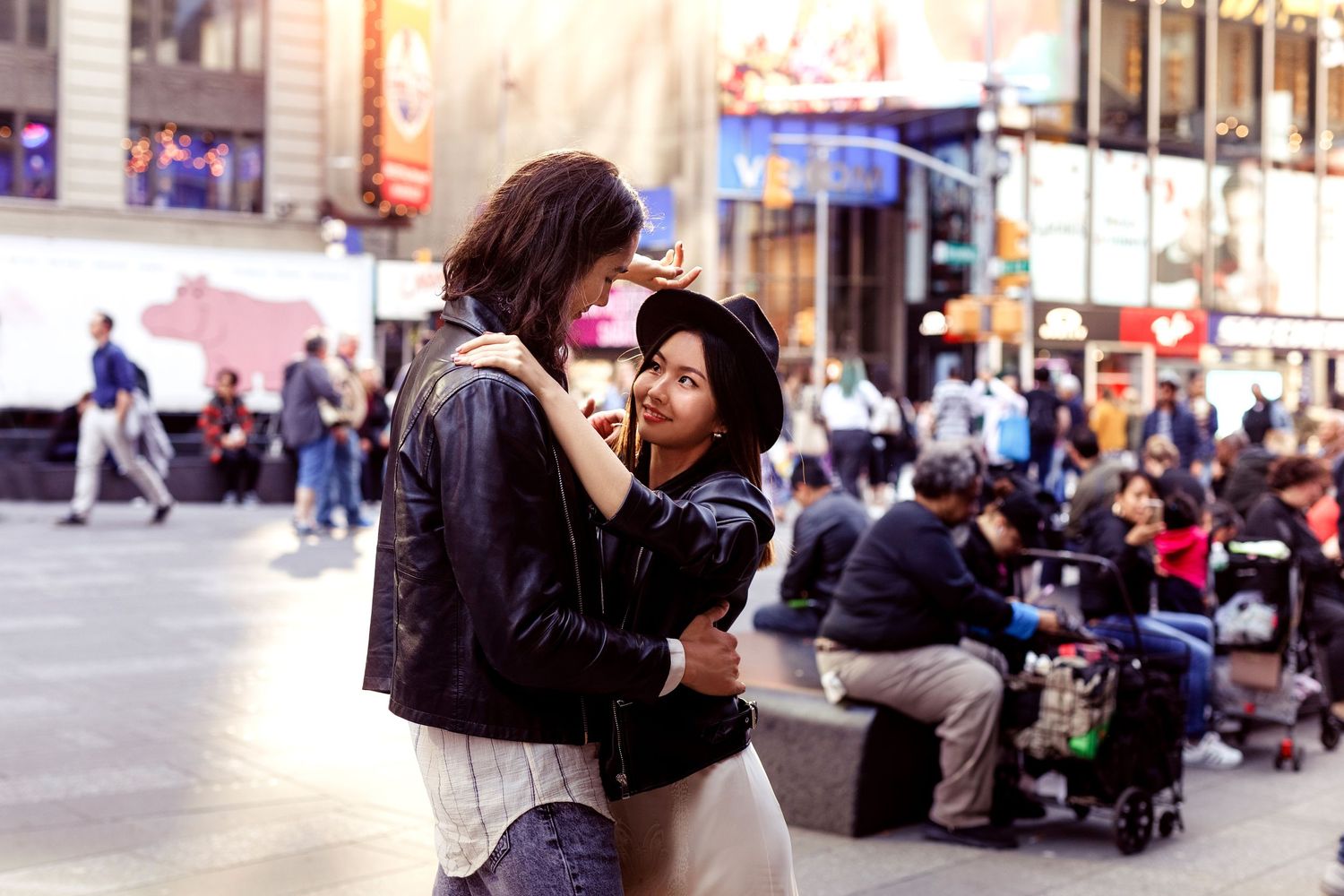 Romantic street scene in Times Square with city lights and crowds in background.