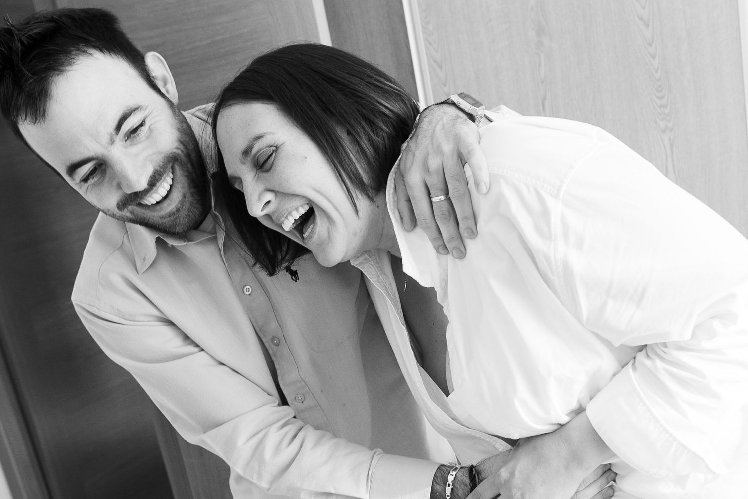 Intimate black and white photo of couple sharing joyful moment together.