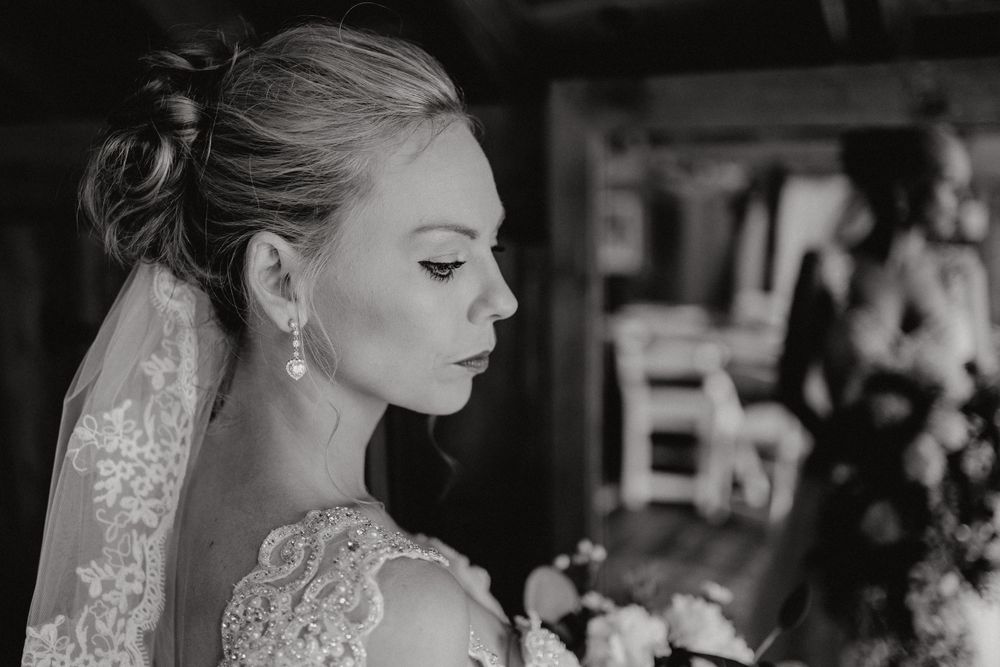 Black and white image of bride after finishing getting ready.