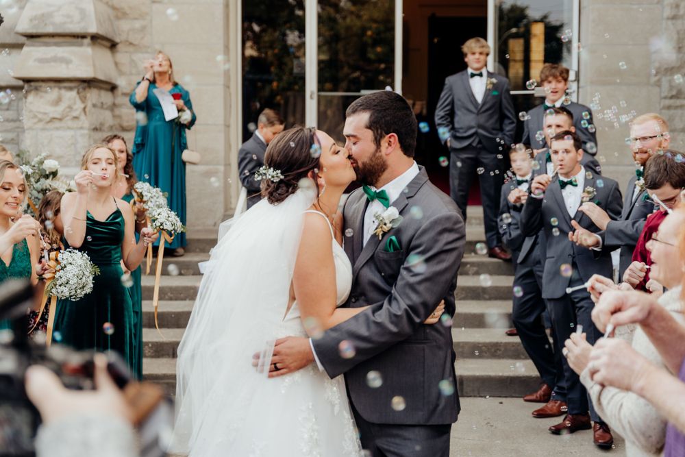 Recession line. Bride and groom kissing.