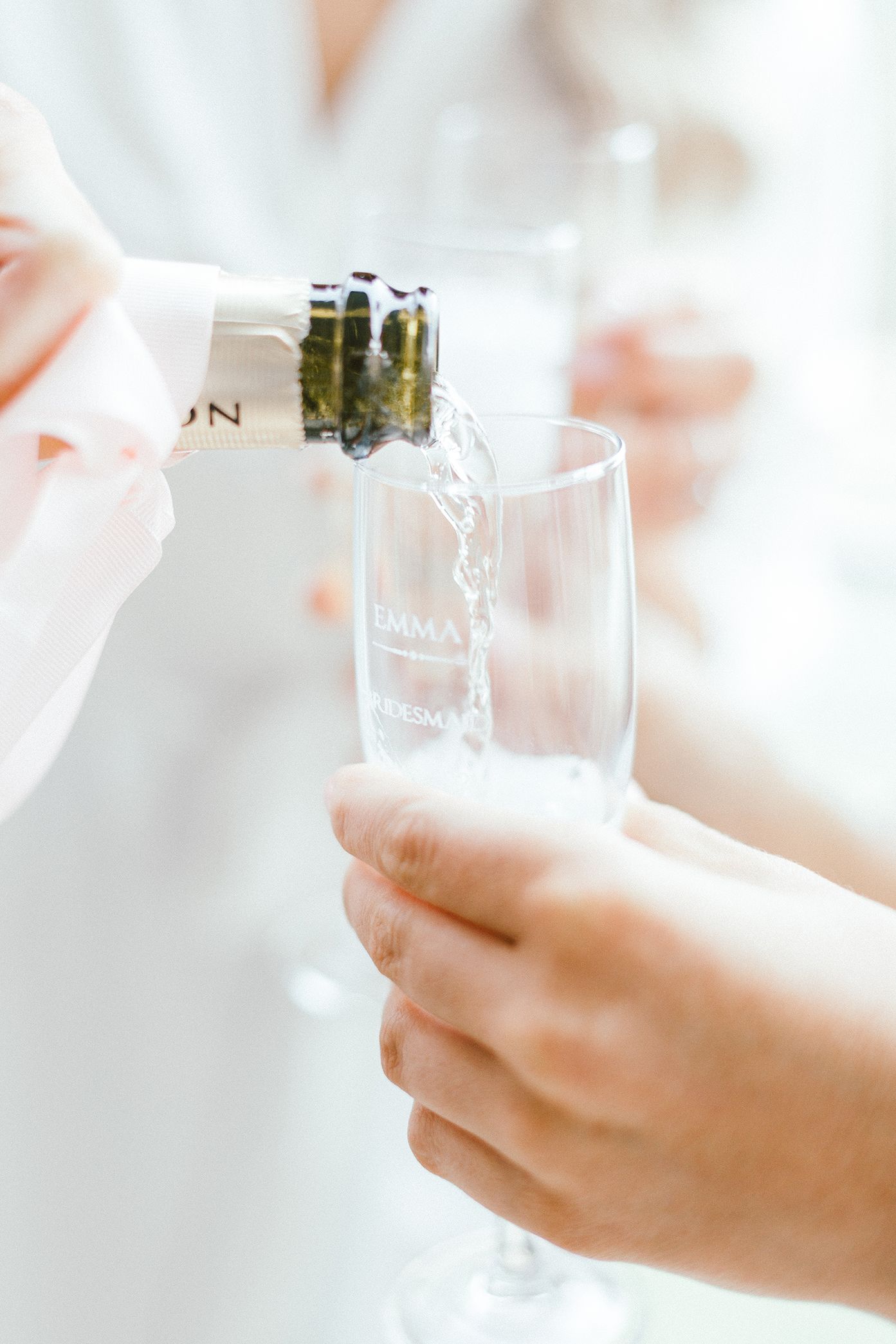 Pouring champagne into a clear glass flute.