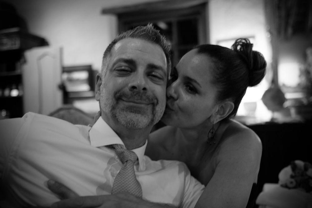 Black and white photo of a happy couple posing closely together at a wedding reception venue.