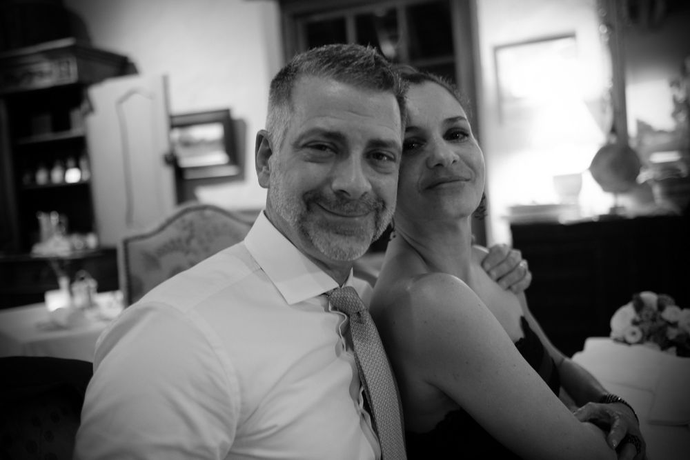 Black and white portrait of a couple posing together smiling at an elegant wedding reception.
