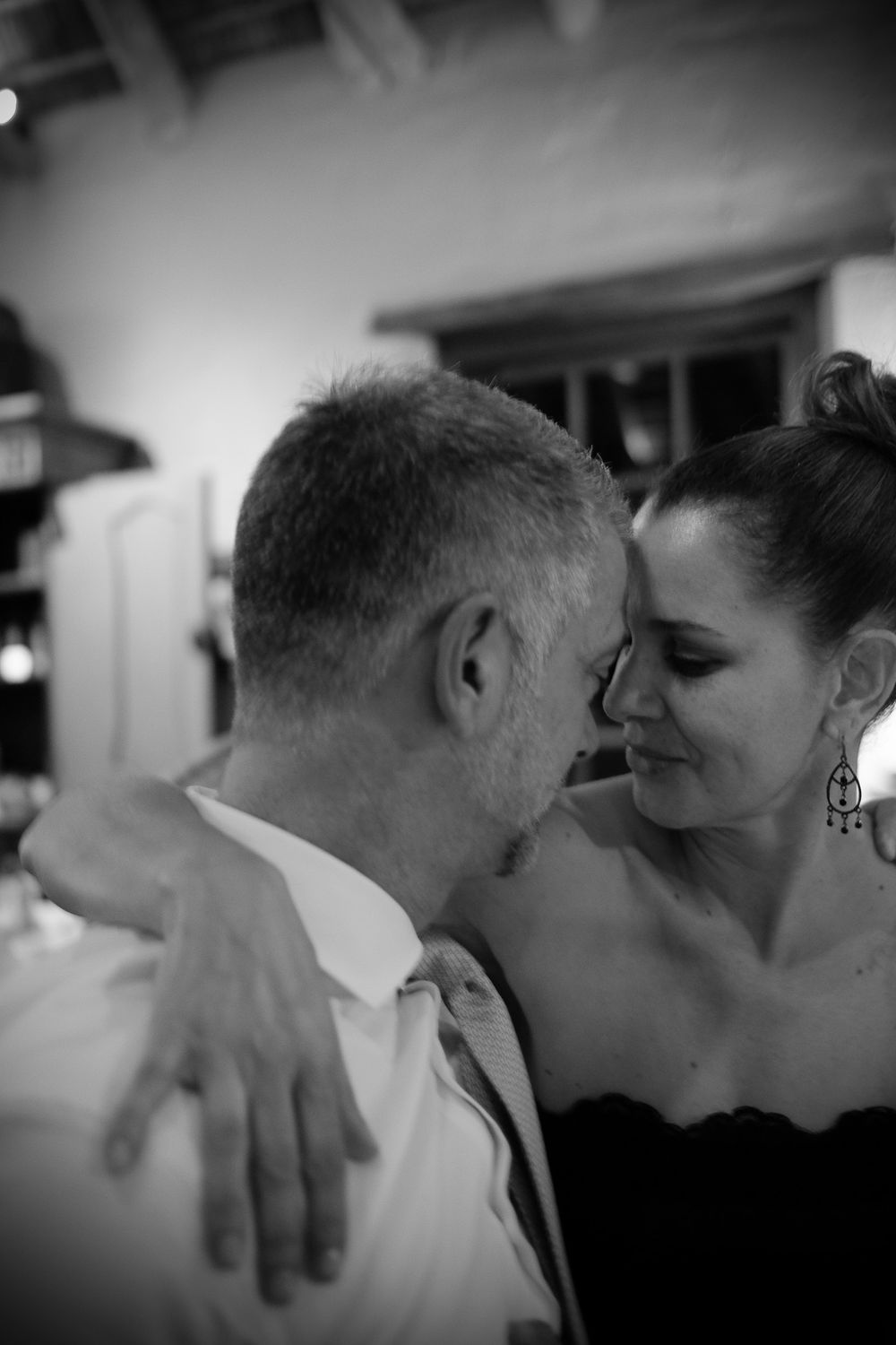 Romantic black and white close-up of a couple sharing an intimate moment on the dance floor.