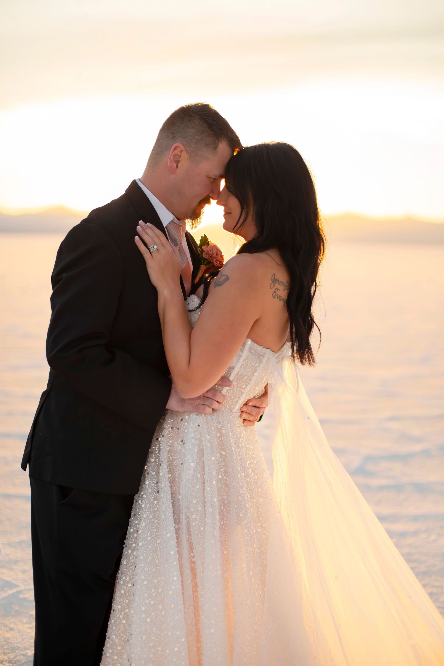 Intimate wedding moment captured during golden hour on salt flats.