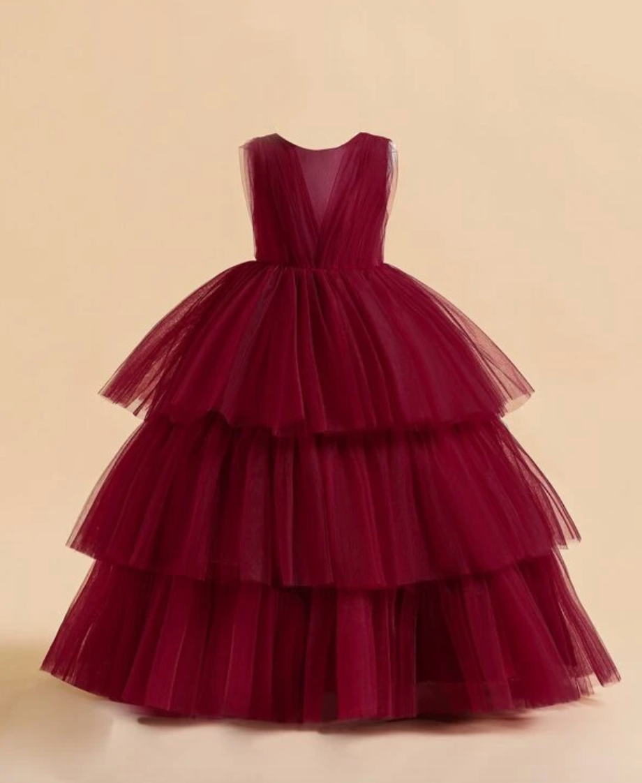 Burgundy tulle ball gown with three tiered ruffled skirt and plunging V-neckline.