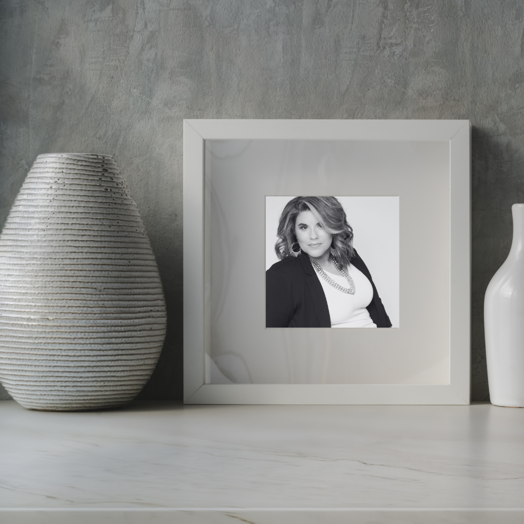 picture frame next to clay pottery with a black and white image of a woman with dark short hair and white top with black