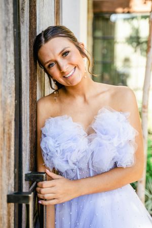 A white tulle wedding dress with ruffled details is showcased in a series of romantic outdoor portraits.