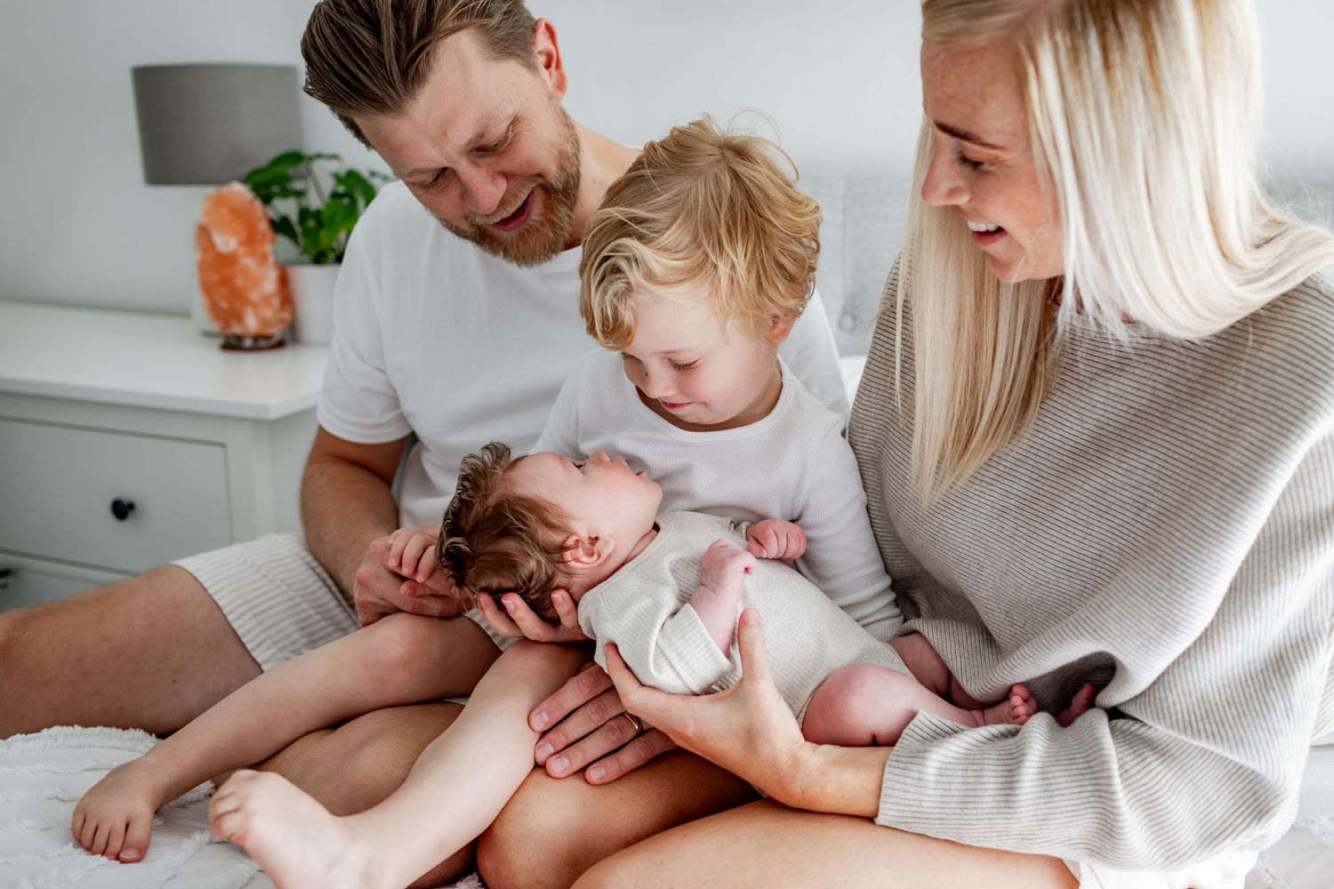 Family spending quality time together on bed in bright bedroom.