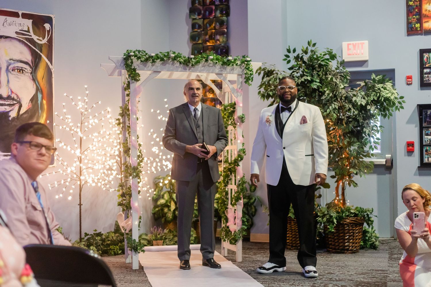 Wedding ceremony venue decorated with string lights and floral arrangements.