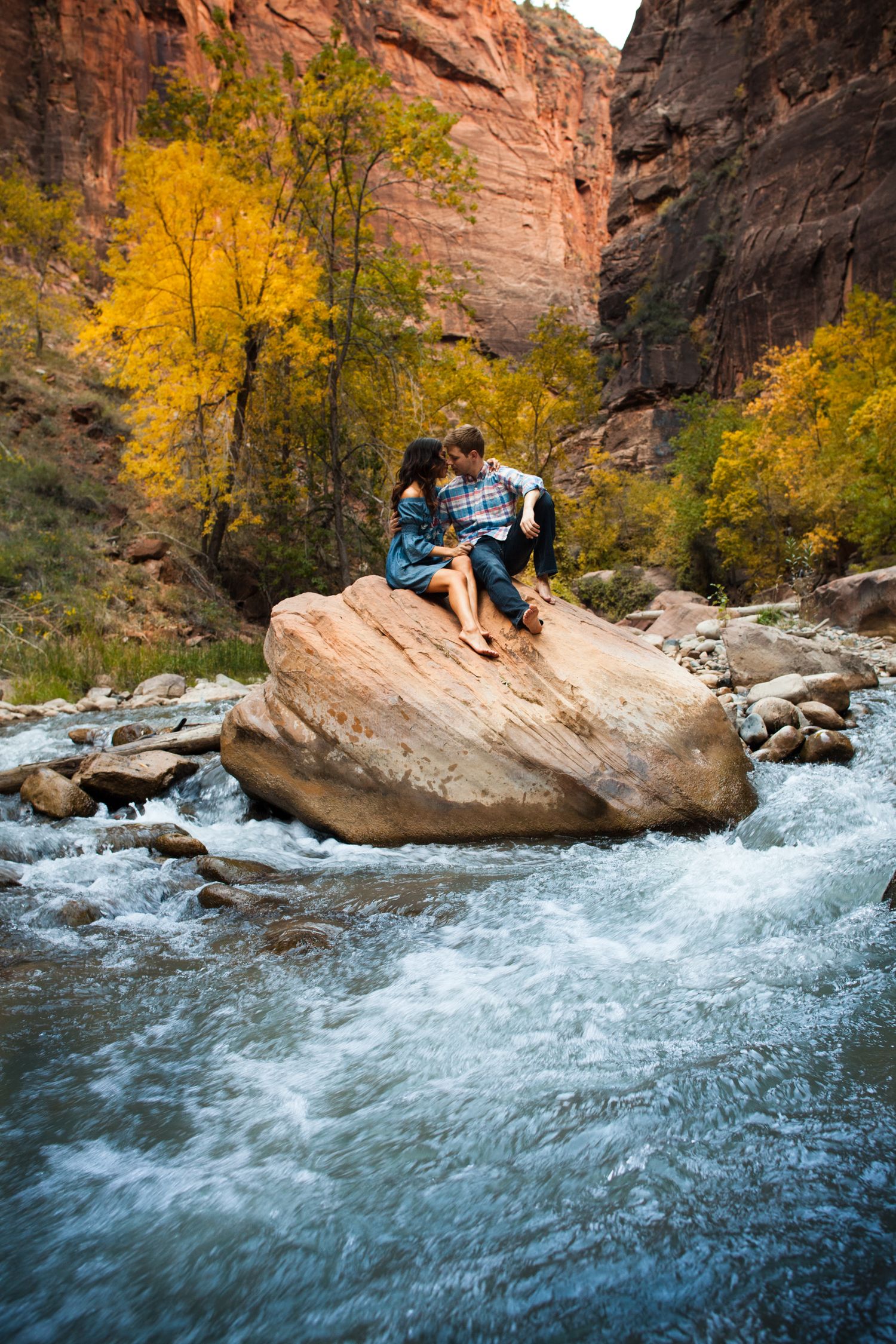 Couple on a rock in a river at Zion National Park.