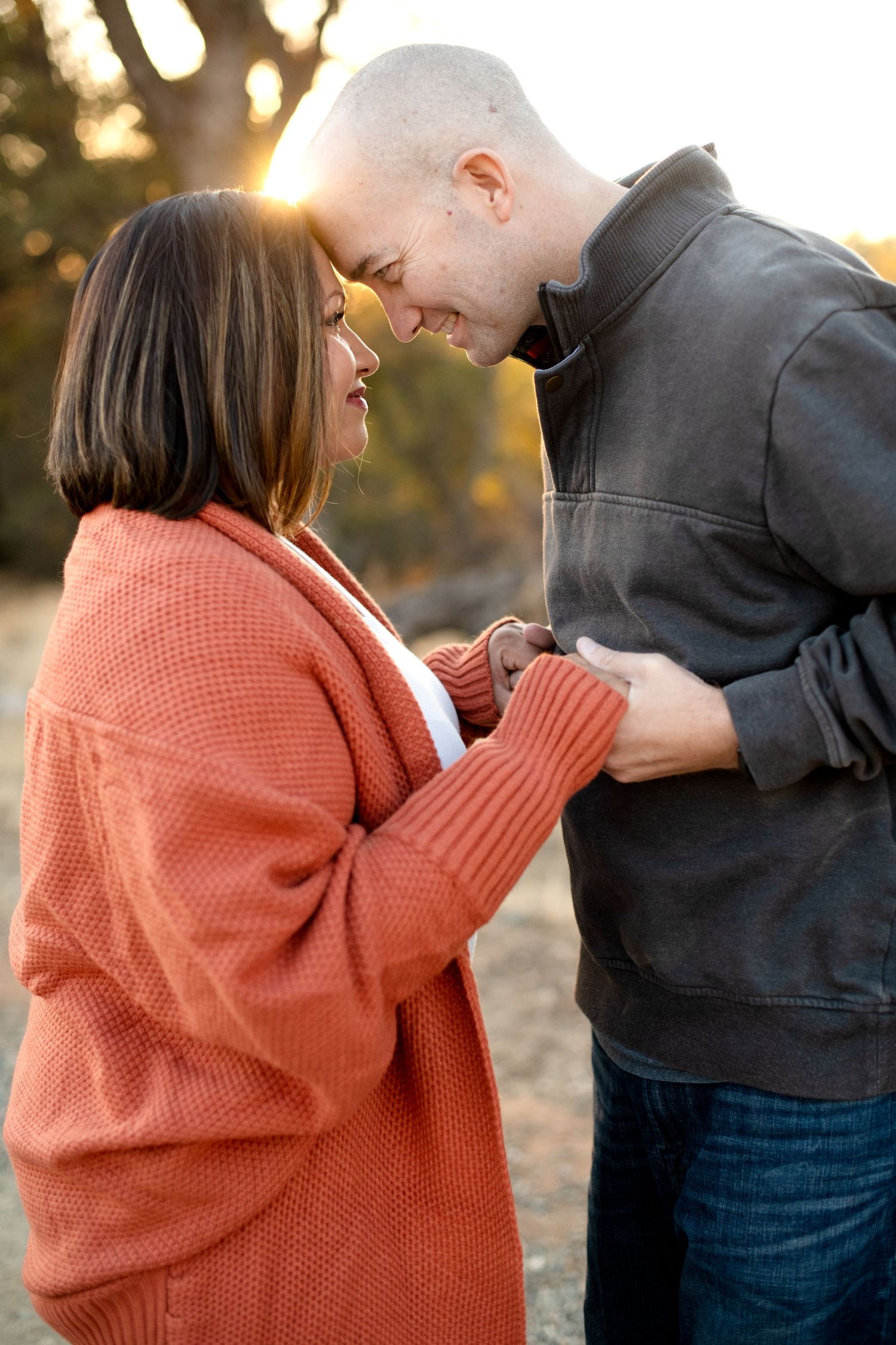 Sequence of heartwarming interaction between two people wearing orange and grey sweaters at sunset.