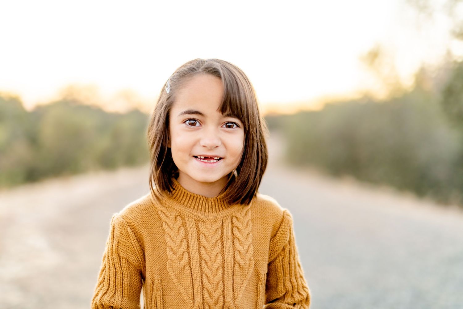 Portrait series of young person in mustard yellow cable knit sweater during golden hour.