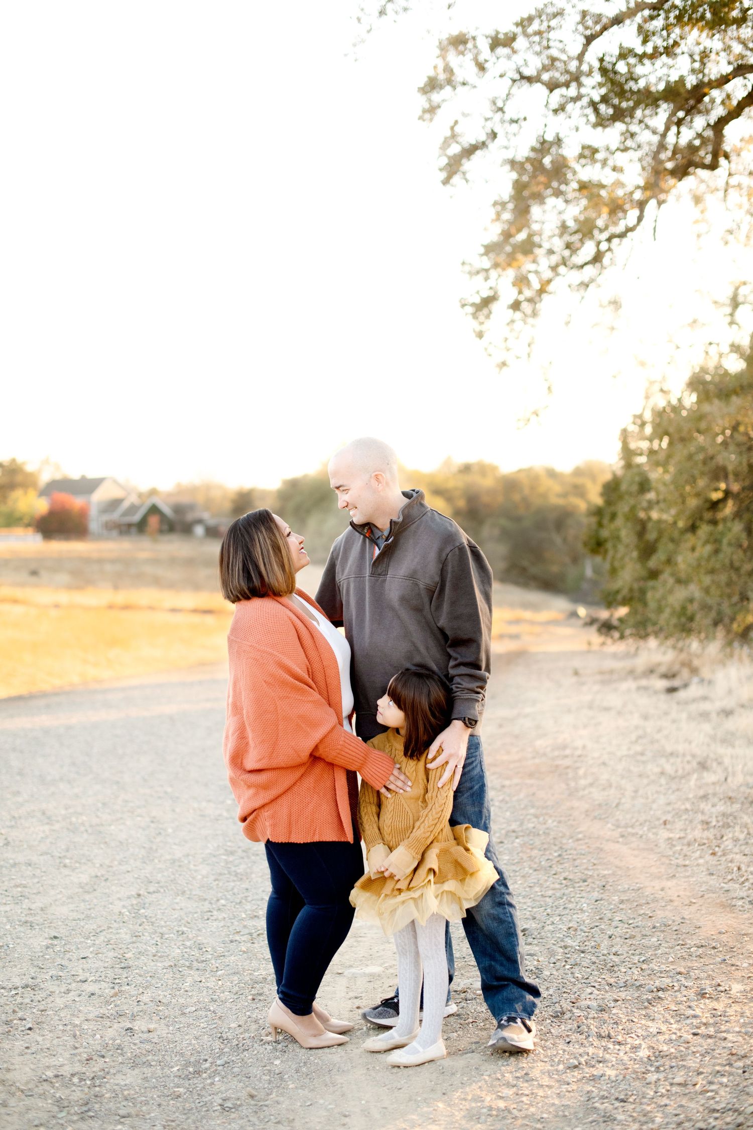 Family members interact playfully on a nature trail during sunset photography session.