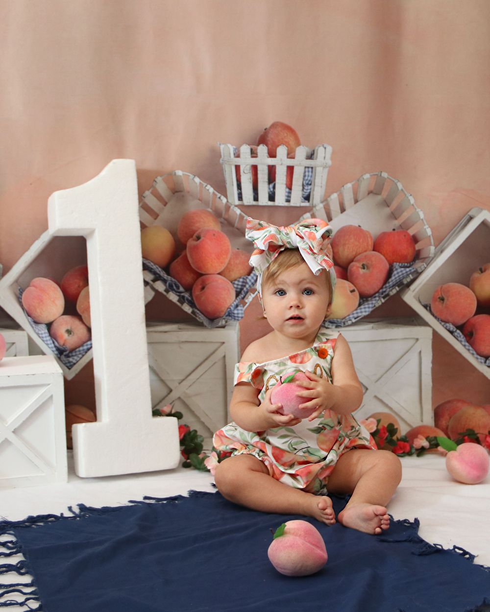 First birthday setup with peach decorations and a large white number one.
