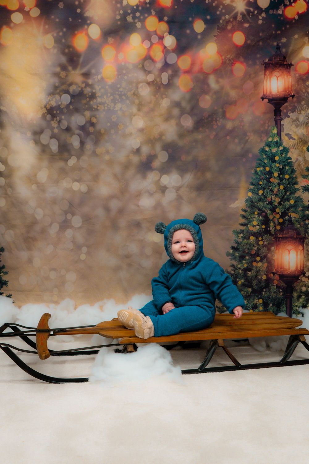 Winter holiday scene with wooden sled, Christmas tree and bokeh lights in background.