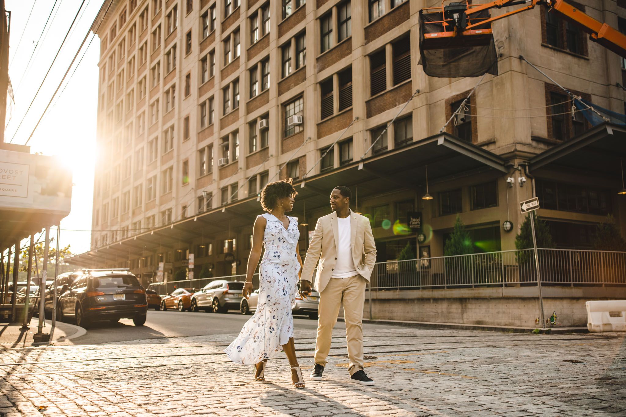 backlit sunset portrait or a couple walking a cobblestone street at sunset in jersey city
