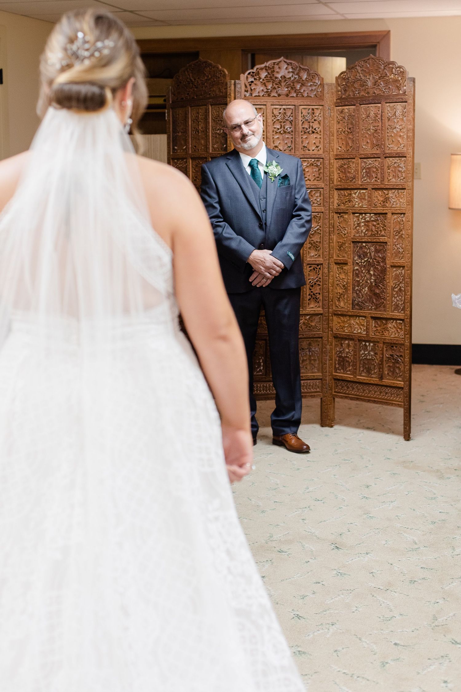 Emotional first look between bride and groom in formal attire.
