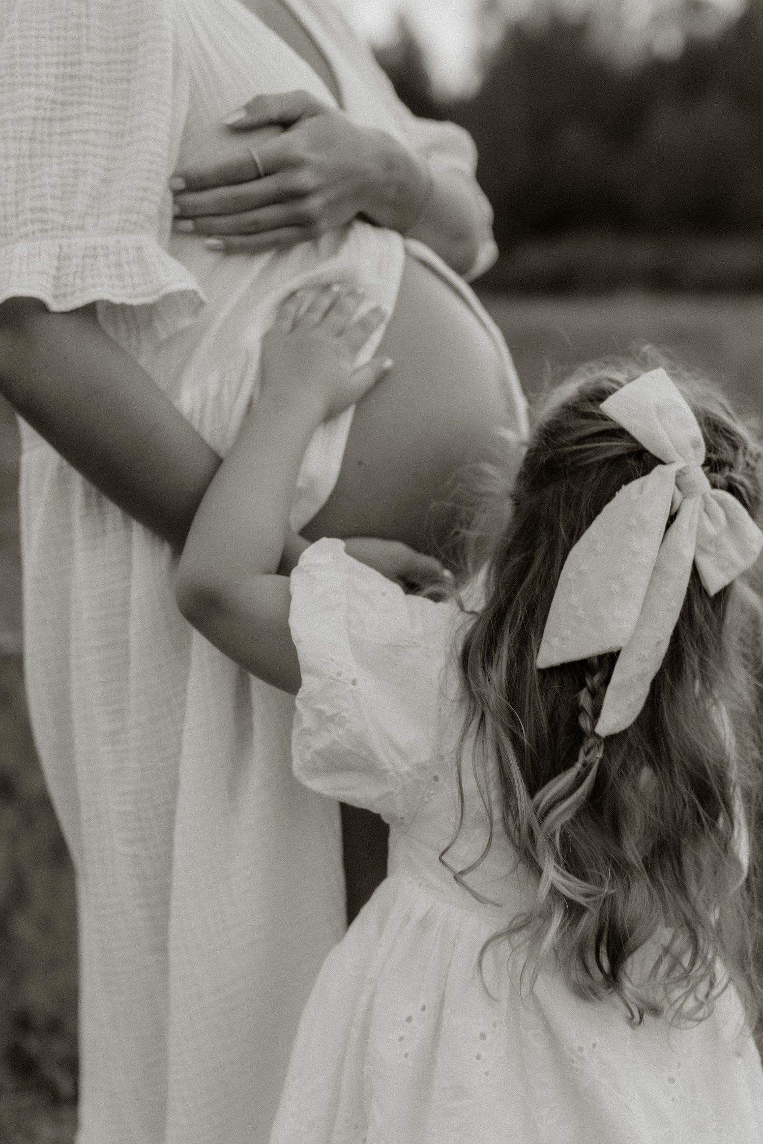 gravid mamma med storasyster som klappar magen
