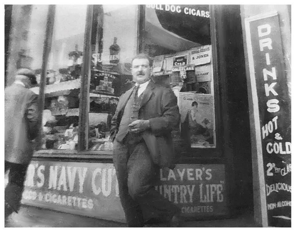 Black and white storefront photo showing tobacco shop with Navy Cut cigarette advertisements.