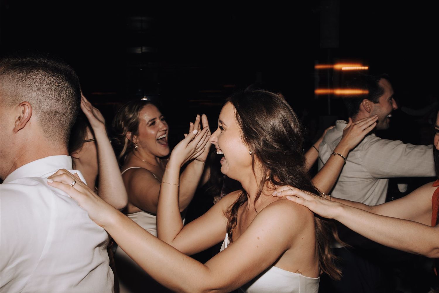 Wedding guests dancing enthusiastically on the dance floor during reception.
