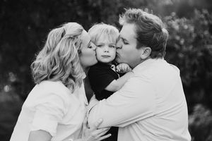 A black and white portrait of a family sharing an intimate moment together.