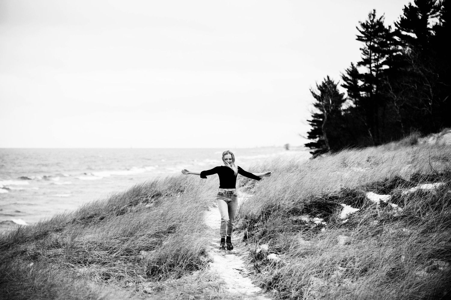 Silhouette poses captured against coastal landscape in black and white.