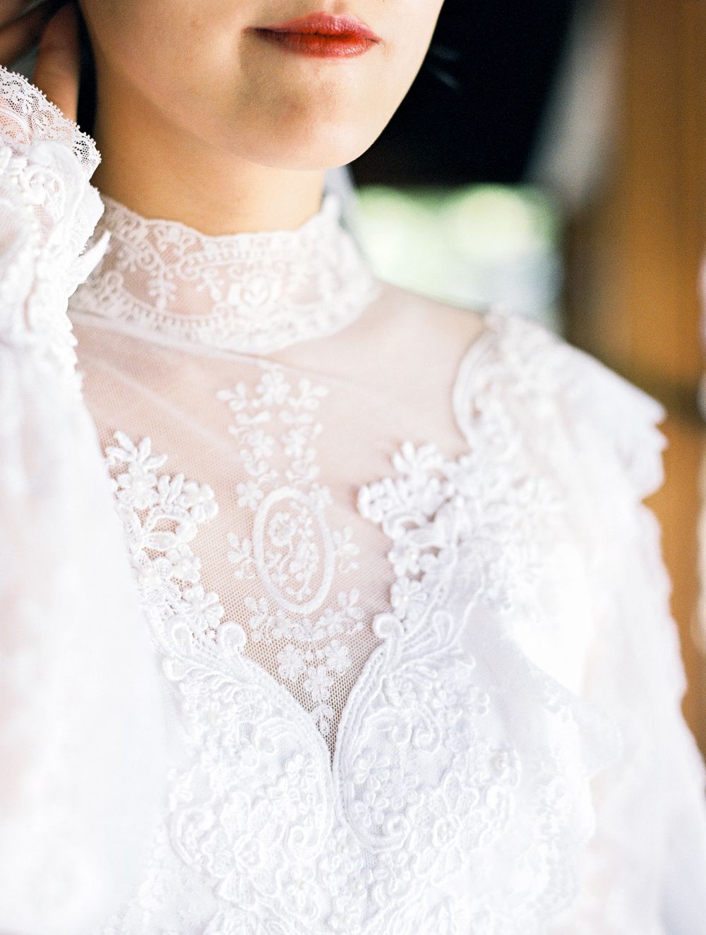 Close up of intricate lace detail on a high neck wedding dress.