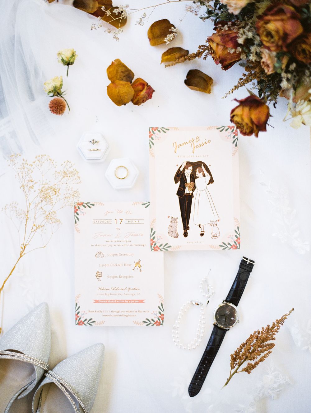 Wedding stationery flat lay with dried flowers and accessories on white background.