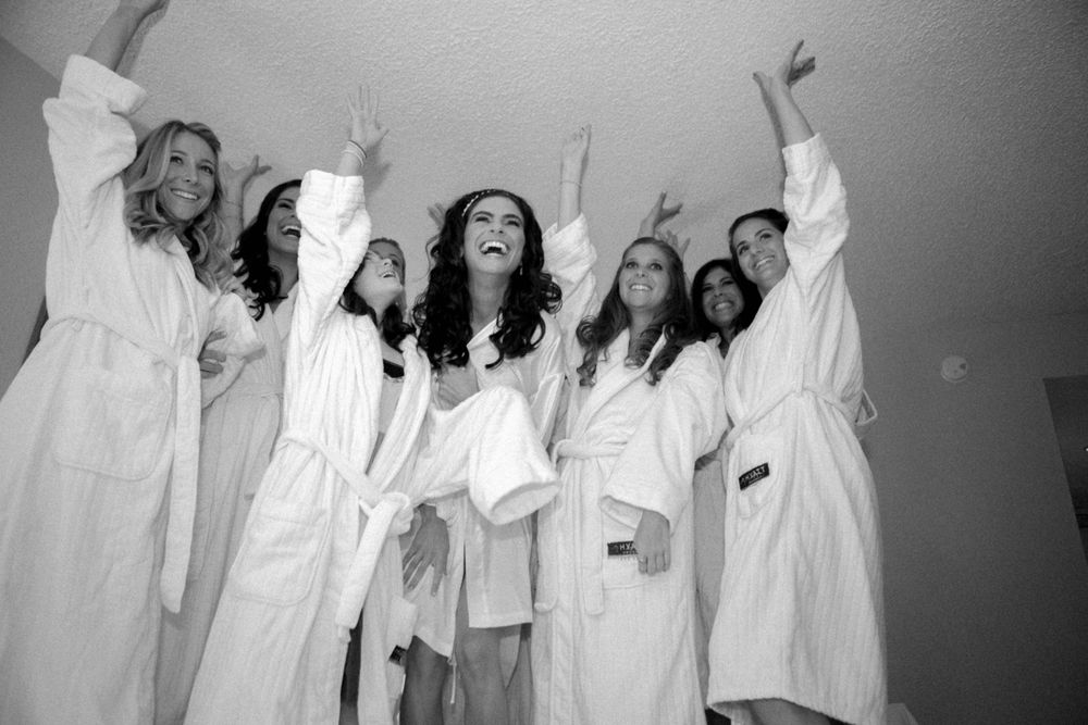A group of women in flowy white dresses dance joyfully during a creative performance piece.