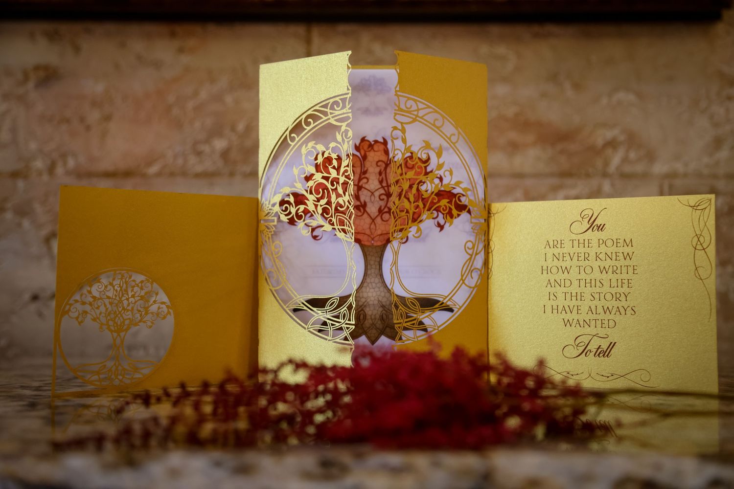 Wedding invitation cards with a golden tree design displayed on a yellow background with decorative elements.