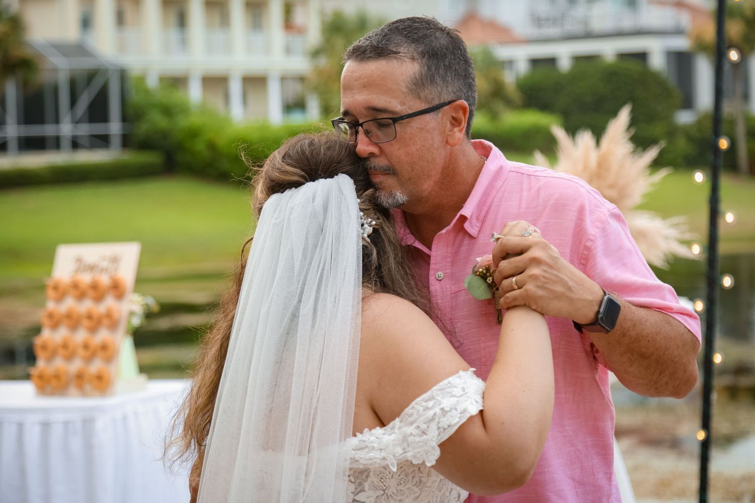 A sweet moment during a wedding reception with donut displays in the background.