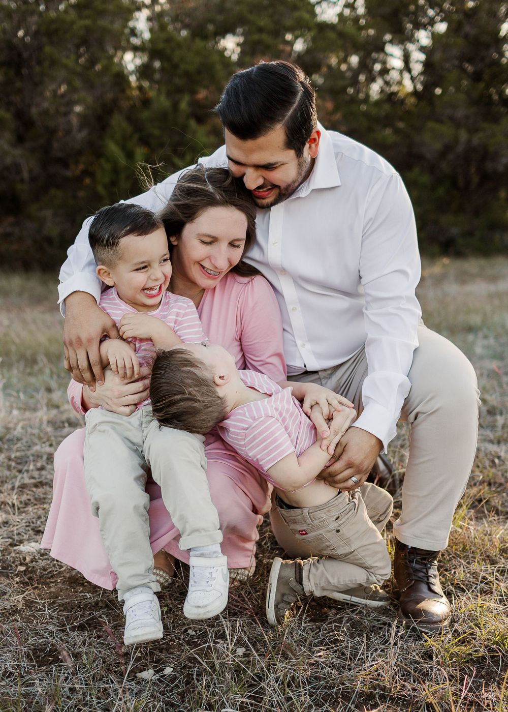 Loving family sharing joyful moment together outdoors during sunset photoshoot.