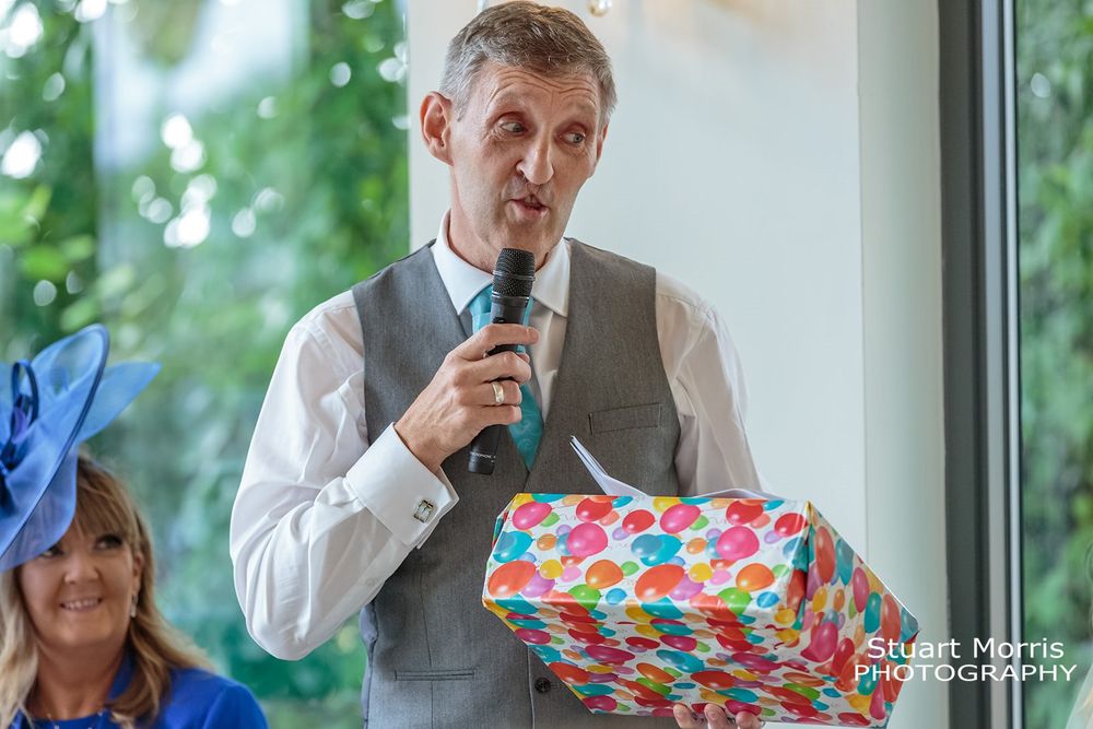 Father of the bride holds a gift during the wedding speeches at west tower Aughton ballroom.