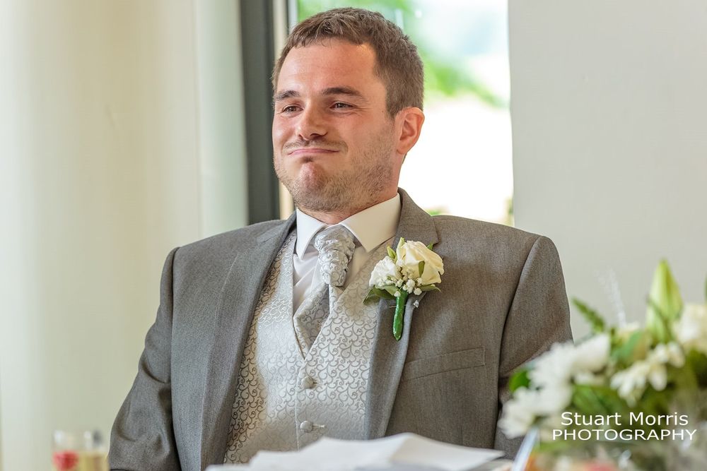 Groom sits down puffing out his cheeks after his speech. West tower Ormskirk country house wedding photographer.