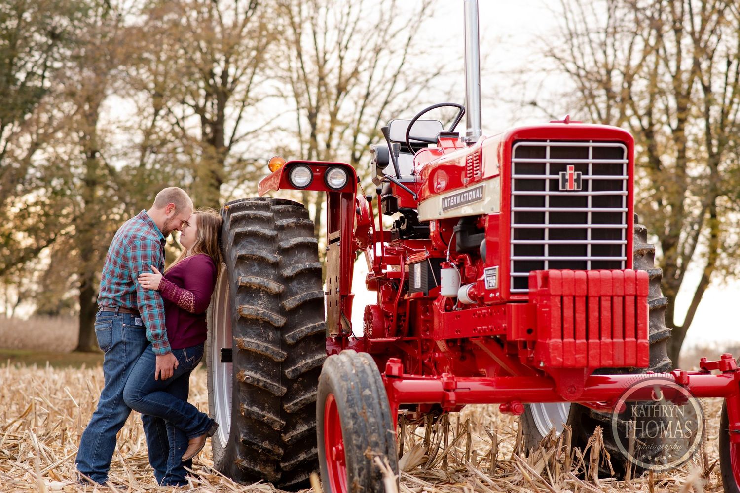A romantic portrait with a restored red vintage tractor in autumn.