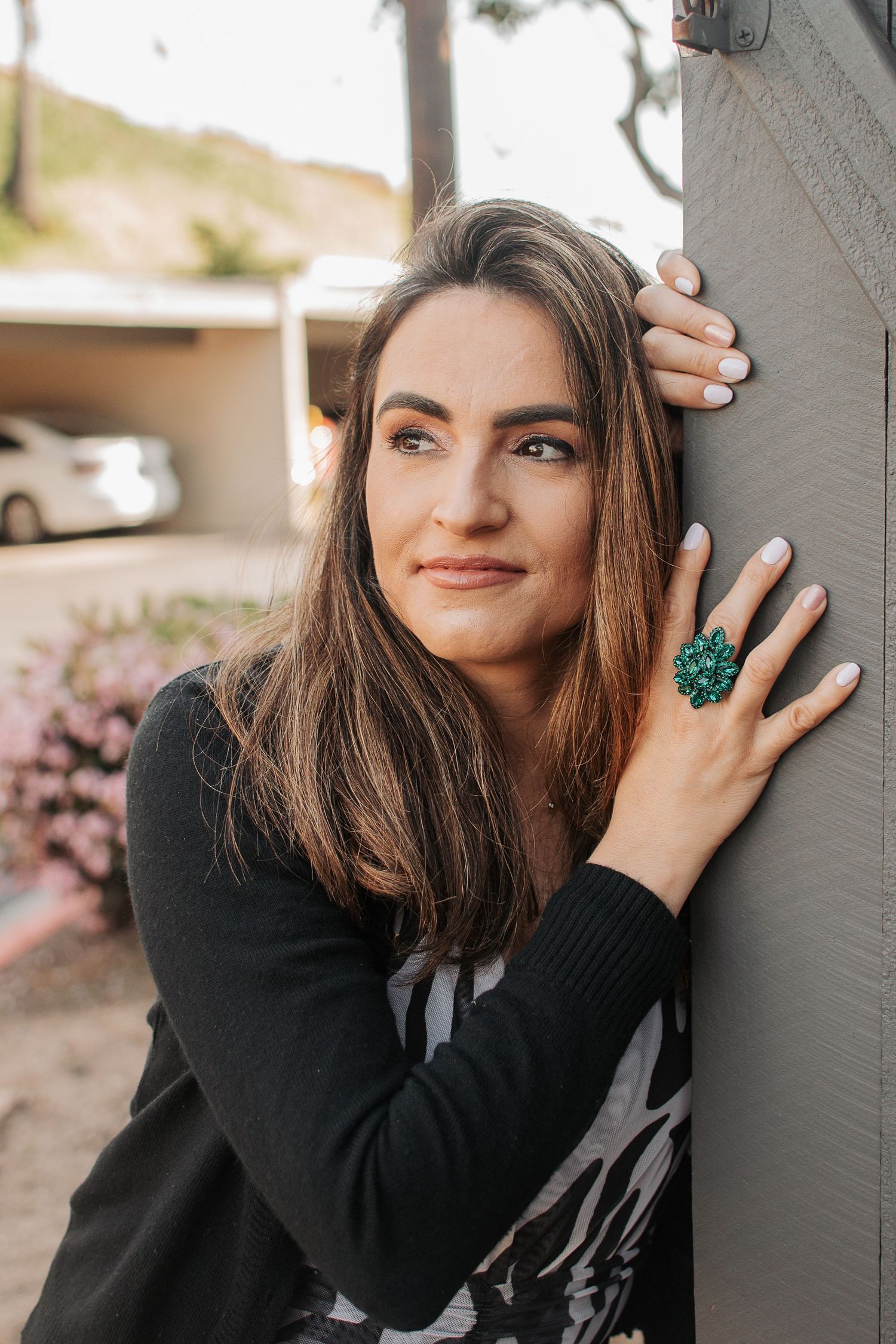 A casual portrait showcasing a striking green statement ring and black sweater.