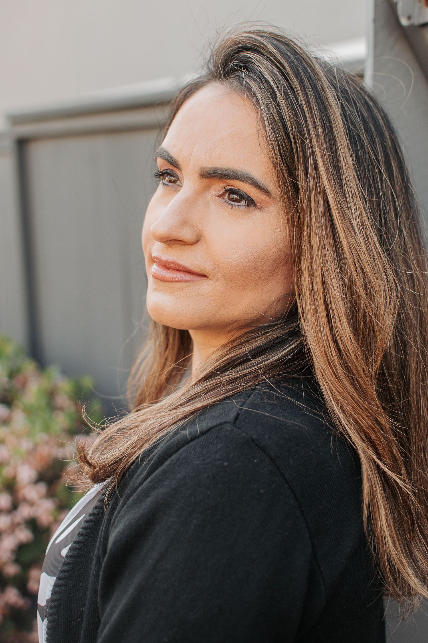 A warm outdoor portrait featuring soft natural lighting and casual black attire.