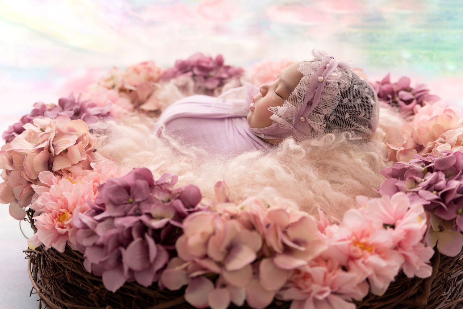 A delicate floral crown with pink and purple flowers rests on a soft textured surface.