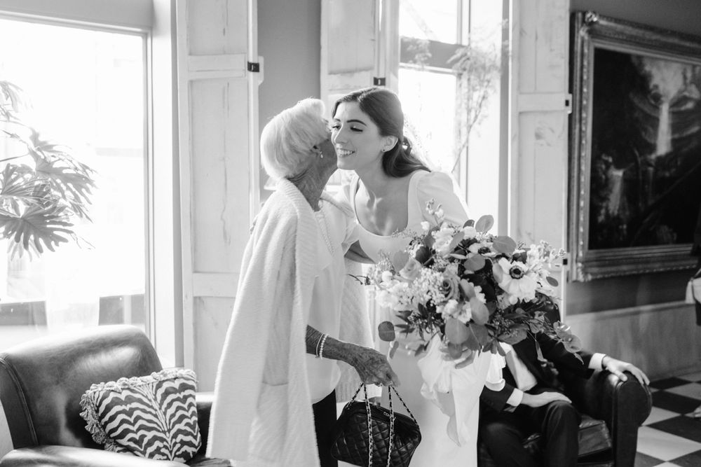 An intimate black and white moment shared between two people with a floral bouquet.