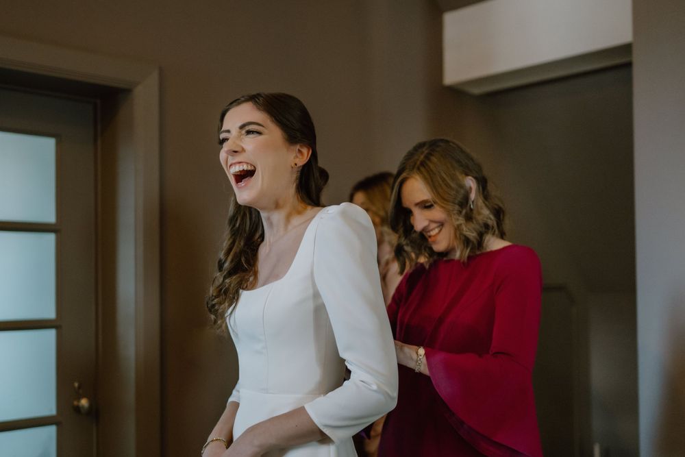 A joyful moment shared between two people during wedding preparations.