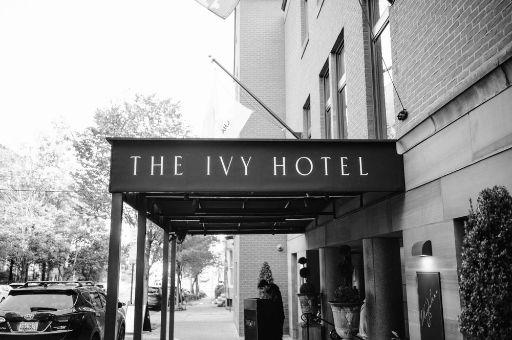 Black and white exterior shot of The Ivy Hotel entrance with awning.