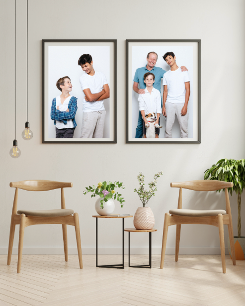 Modern gallery wall displaying family portraits in matching frames with minimalist furniture below.